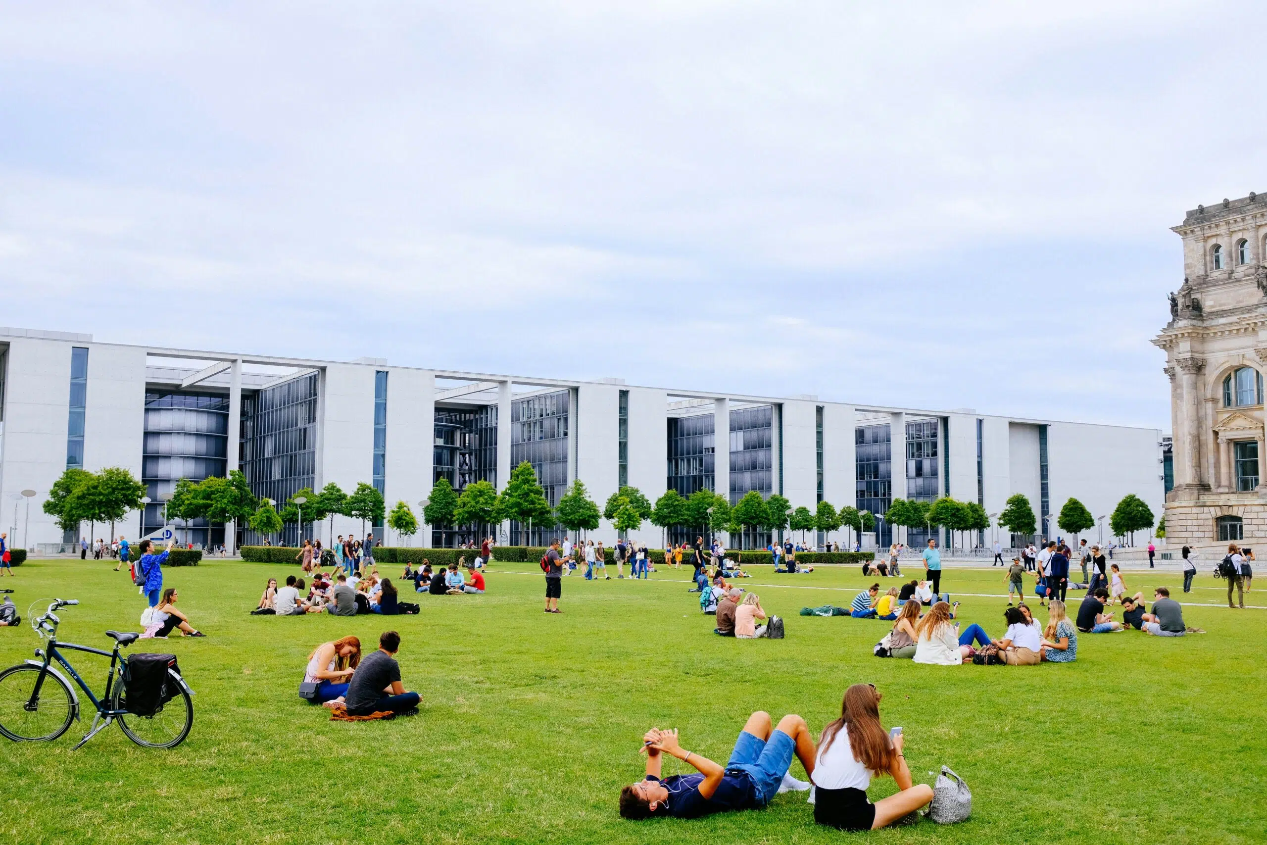 Benifits and cost of Studying Abroad. Students are sitting in open ground in abroad for studying together.